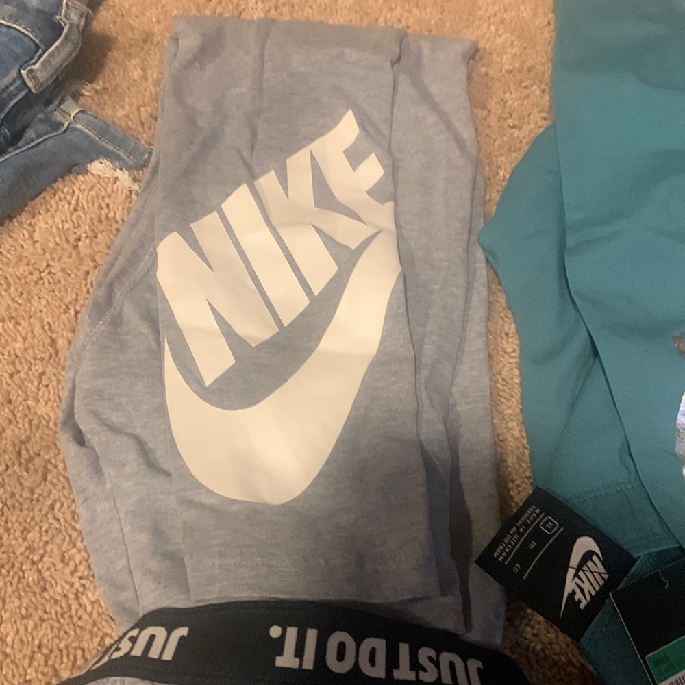 2 pair of NIKE leggings. Teal pair still has tags. Gray pair worn once.
